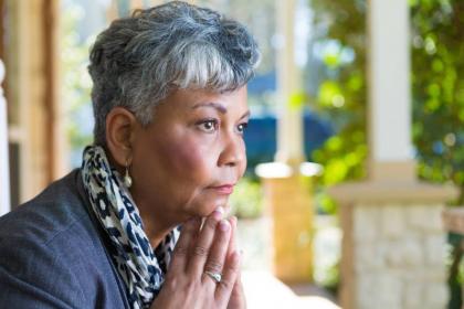 Women in contemplation with hands together under her chin