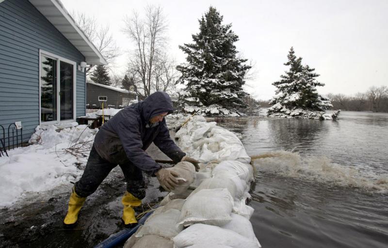 Person stacking sandbags in preparation for flooding
