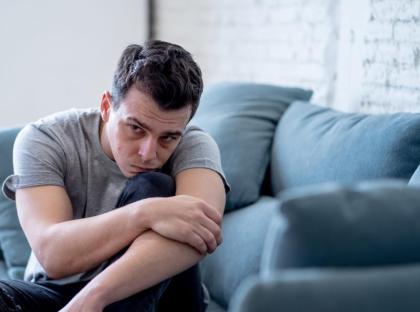 Depressed guy on couch stock photo